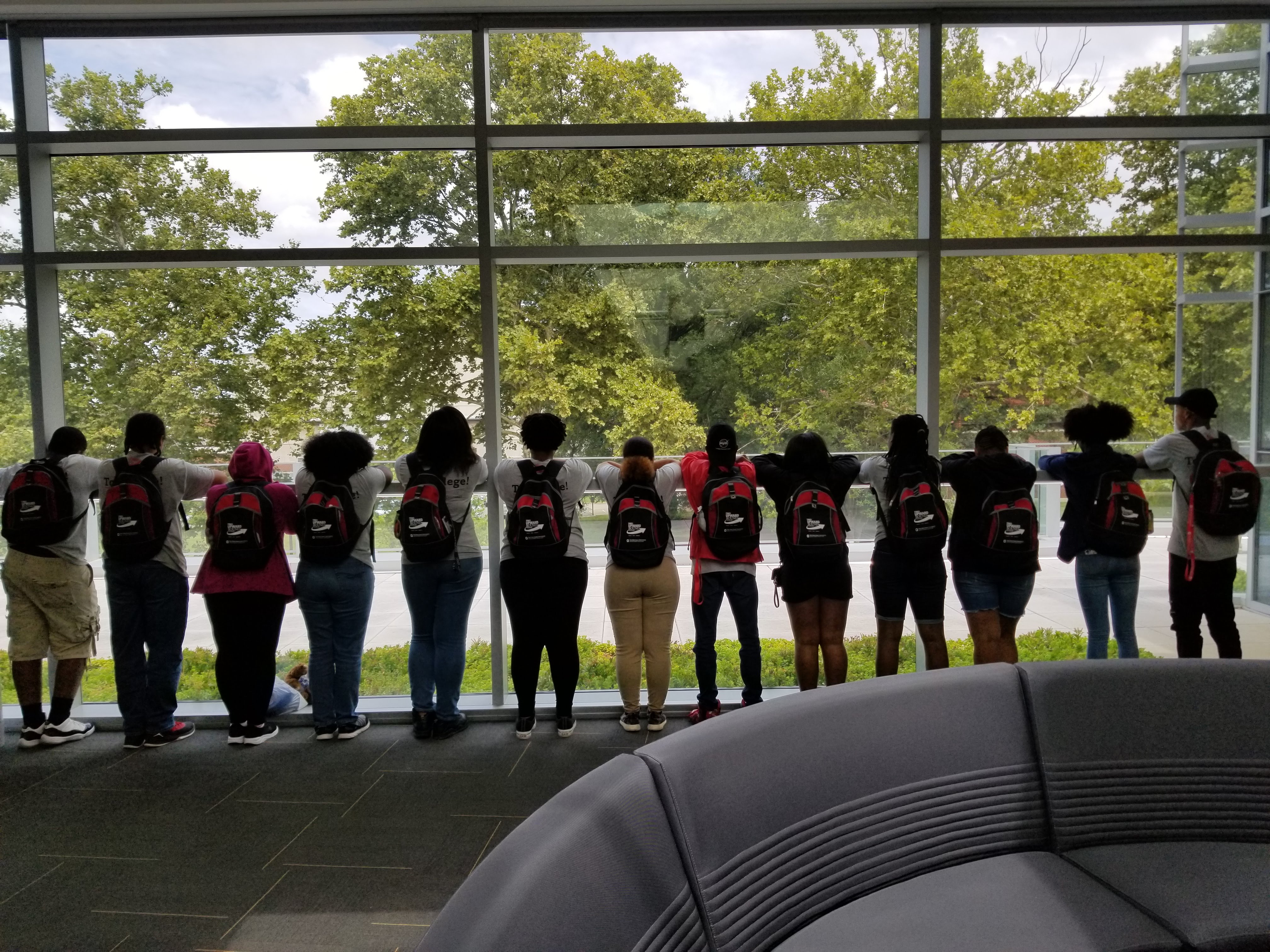 Upward Bound students outlined in front of a large glass window