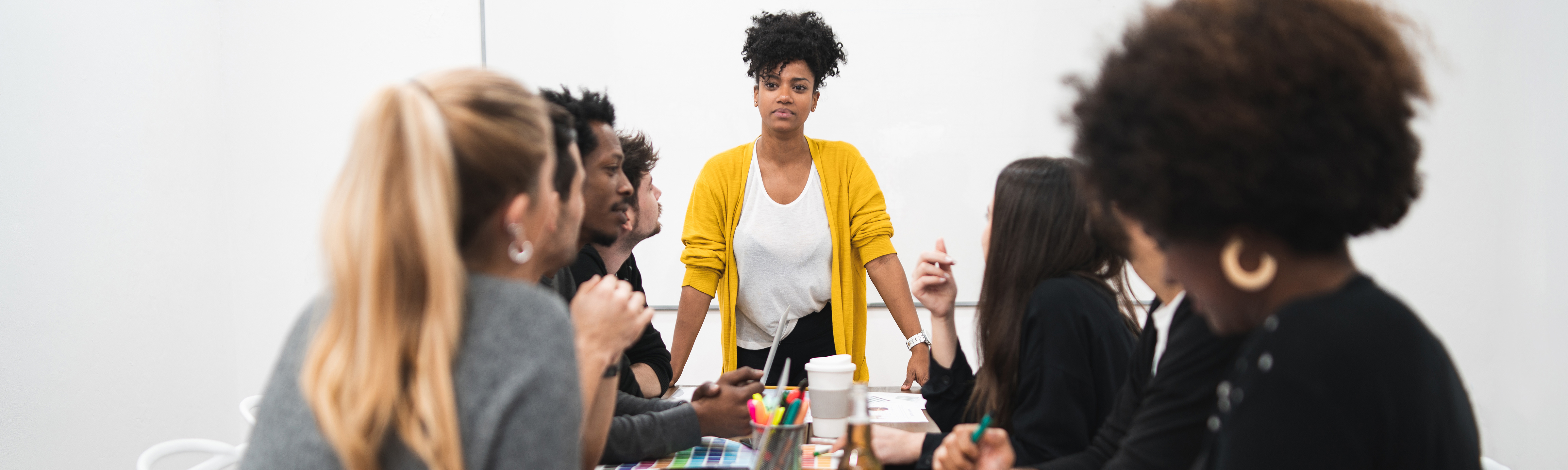 Diverse men and women sit at a conference table