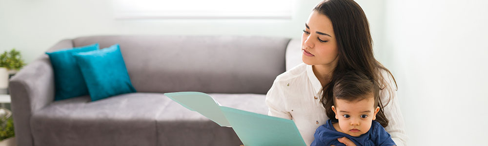 woman reading a piece of paper with child on her lap