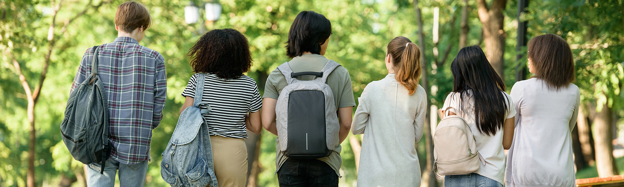 Diverse students walking away with backpacks and book bags