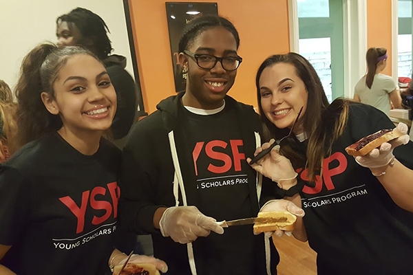 THree girld in black YSP t-shirts make peanut butt and jelly sandwiches