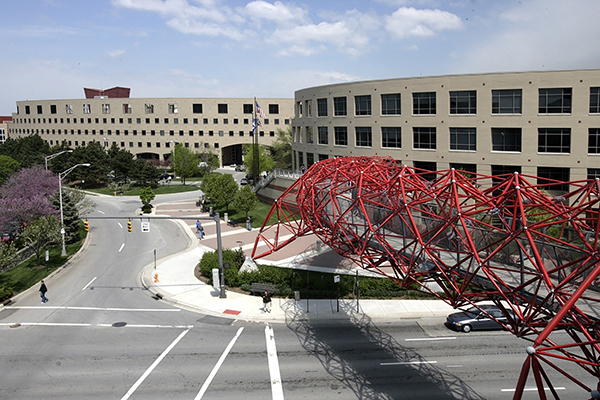 Red twisting pole sculpture at Columbus State Community College goes over a road