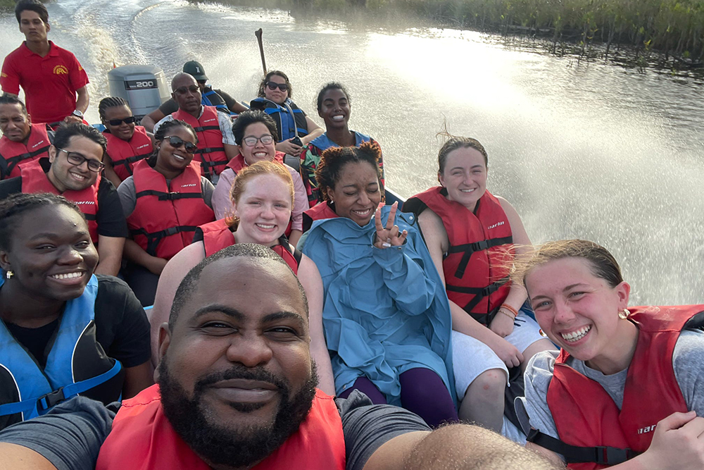 Students in a boat on a river take a selfie