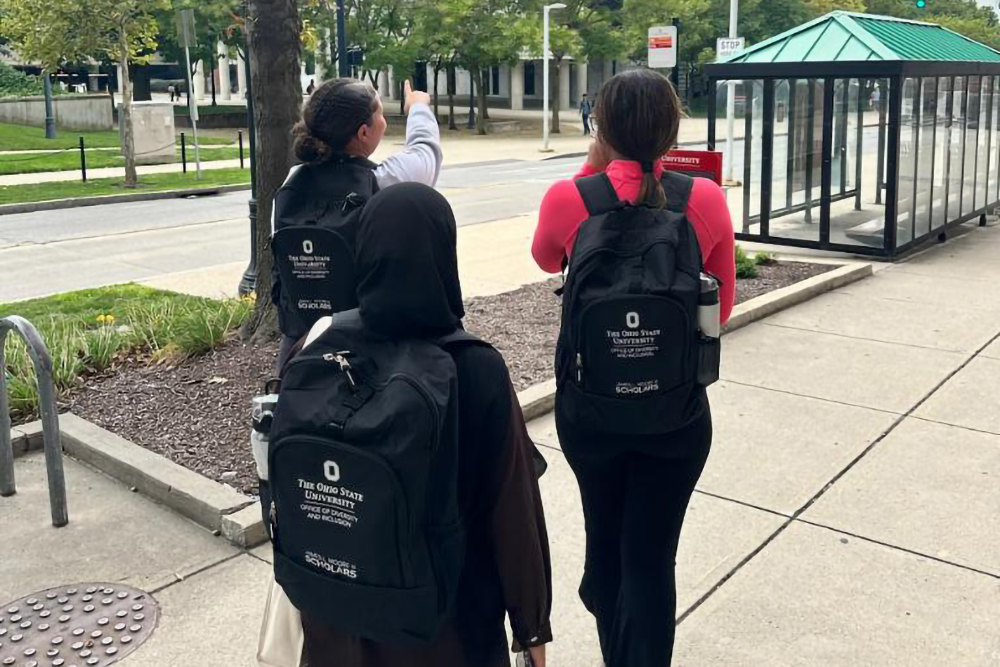 the back of three JLM scholars, all who wear a backpack