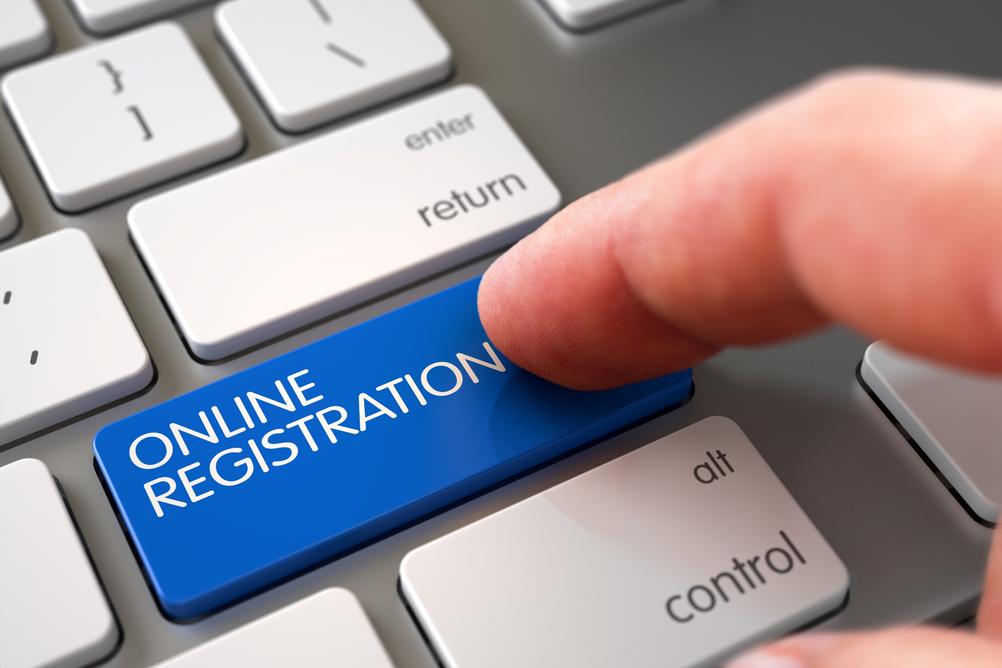 finger pushing a button that says online registration