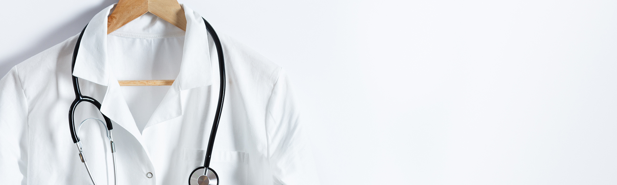 Physician's white coat on a hanger with a stethoscope