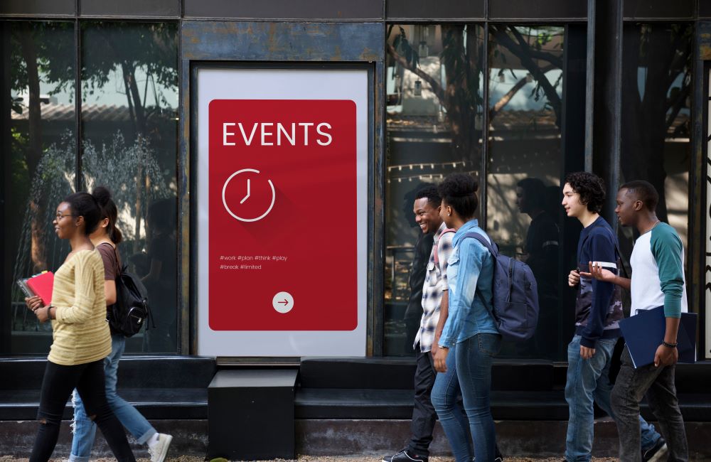 people walking by a sign that says Events with a line drawing of a clock under it