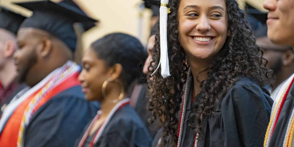 ODI grad in cap and gowns smiles at the camera