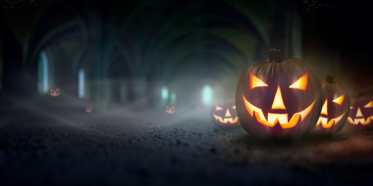 Lighted Jack O'Lanterns on a misty, dark road