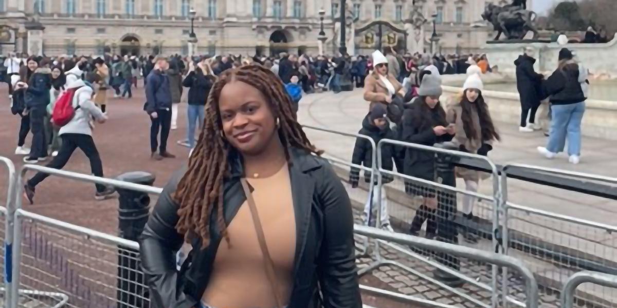 Kyla Hurns, a Black woman, stands in from of a building in London, England