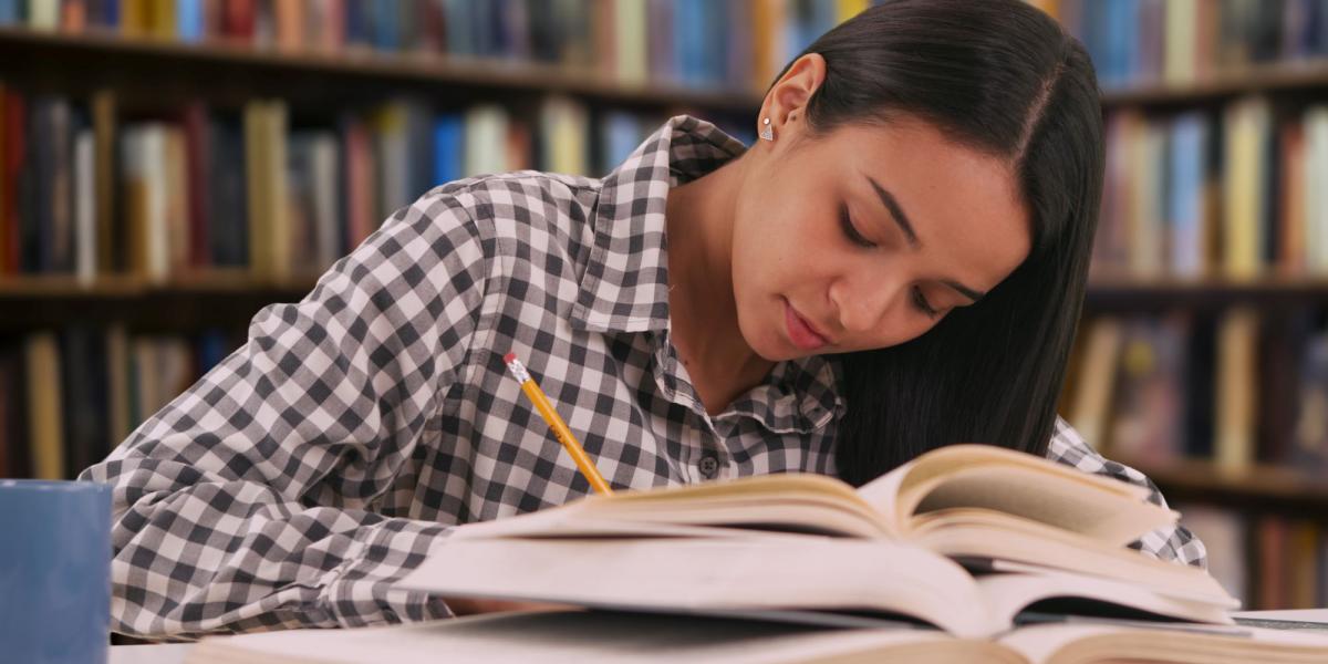 Latine students studying in a library with open books