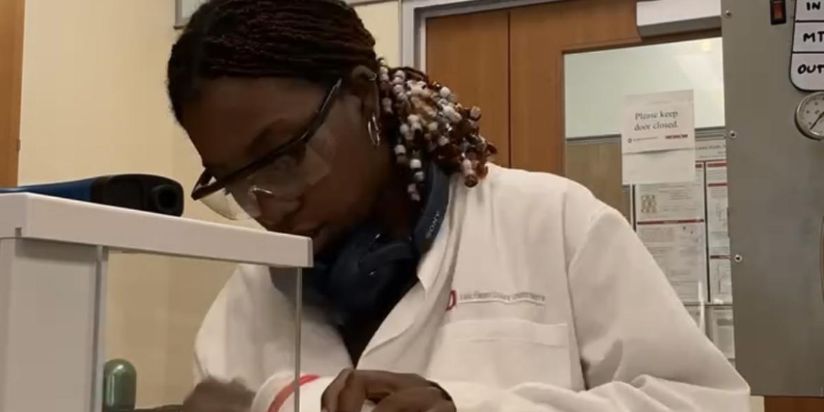 Mackenzie Hoffman in a white lab coat measuring powders