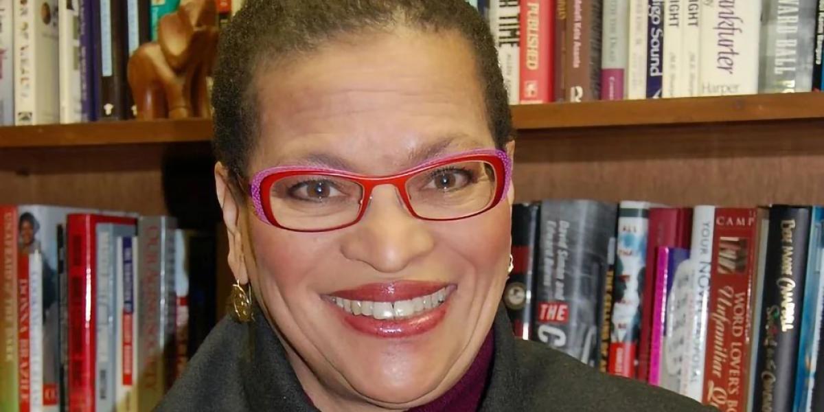 Dr. Julianne Malveaux, in bright pink glasses and an olive coat