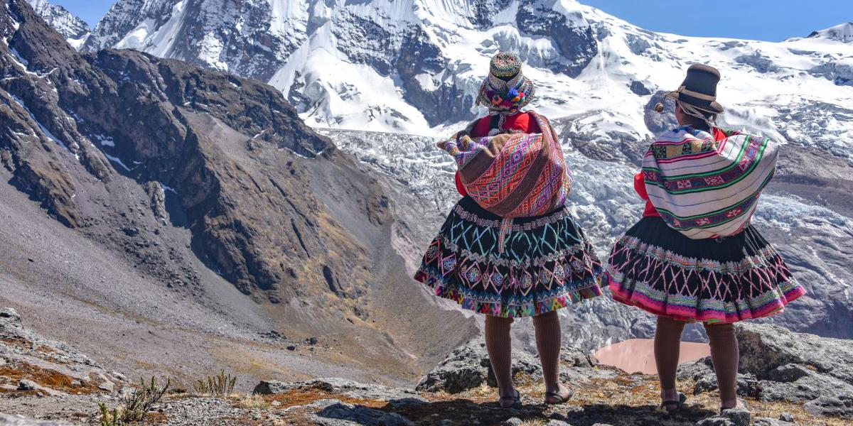 Quechua girls look at snowy mountains