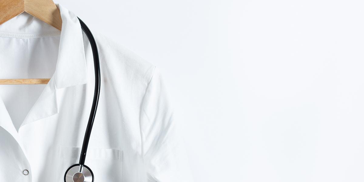 Physician's white coat on a hanger with a stethoscope