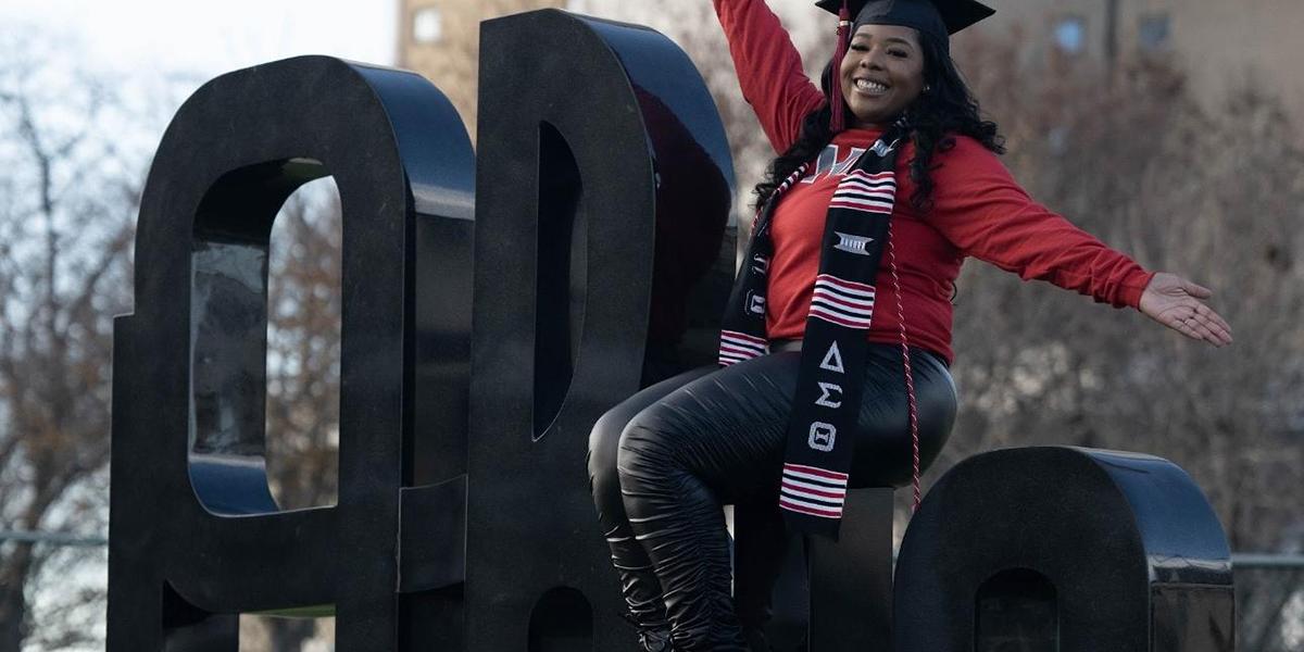 Daechanea Williams sits on Ohio sculpture