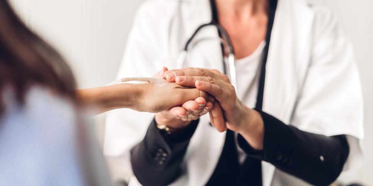 female doctor holds hand of her patient