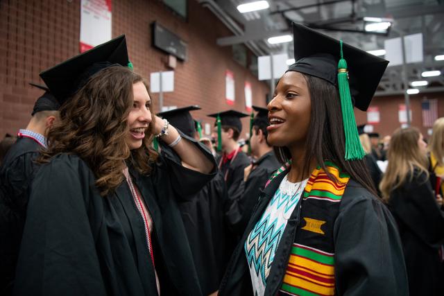 two students in cap and gown for Ohio State graduation