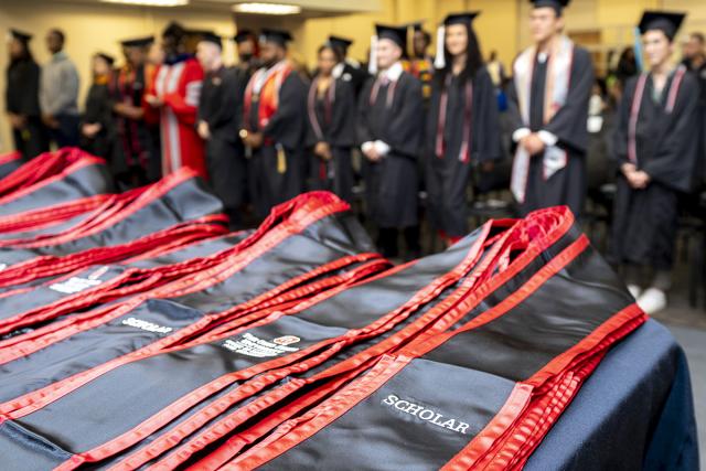 ODI grads stand behind a table with ODI stoles on it