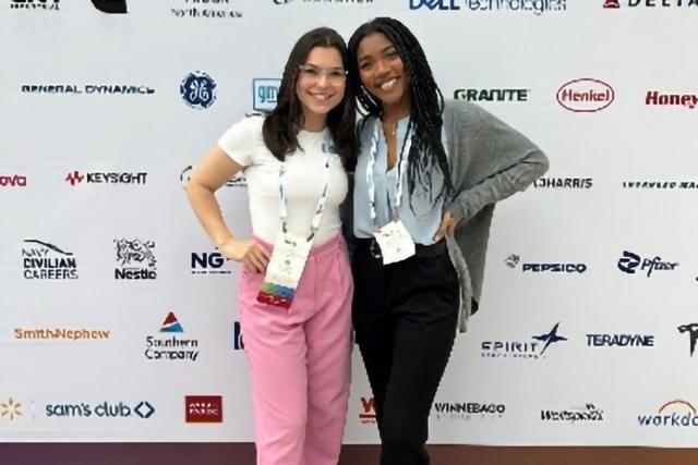 Two students with arm badges and arms around each other