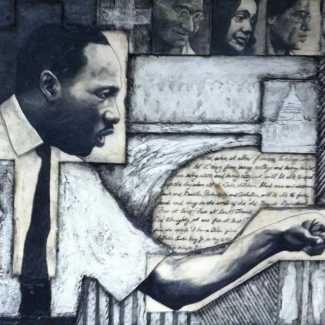 MLK in white shirt and black tie pointing his finger