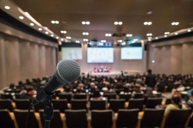 Closeup of microphone with audience in the background