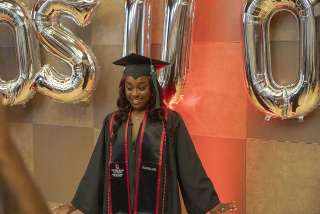 ODI grad standing in front of ODI/OSU balloons