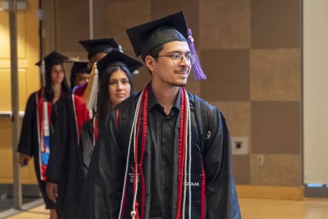 ODI grads in cap and gown line up to enter auditorium for ODI graduation Ceremony