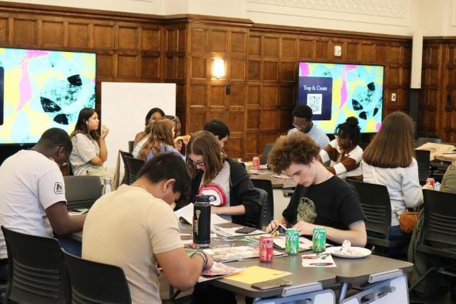 Several students sit at tables working