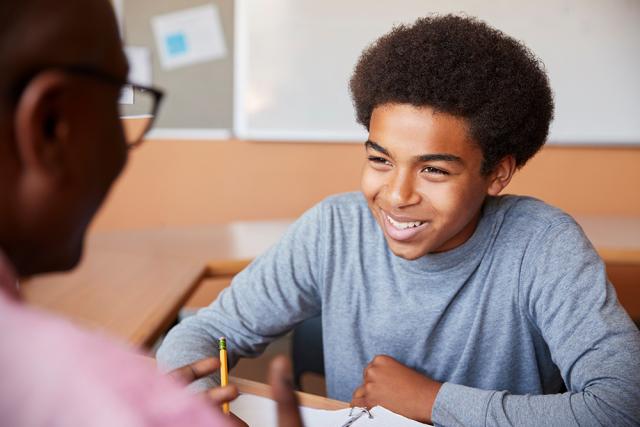 Black student working on homework with a Black male