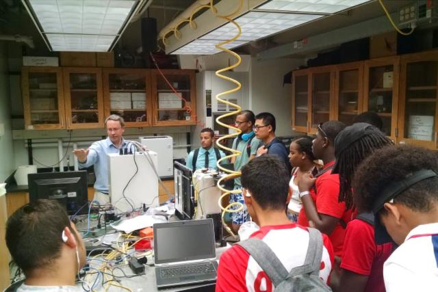 group of students listen to a professor speaking in a mechanical negineering lab