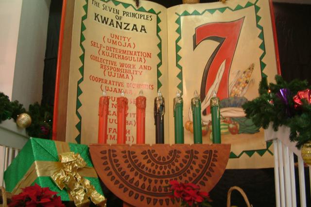 Book with 7 principles of Kwanzaa and three red, three green, and one balck candle