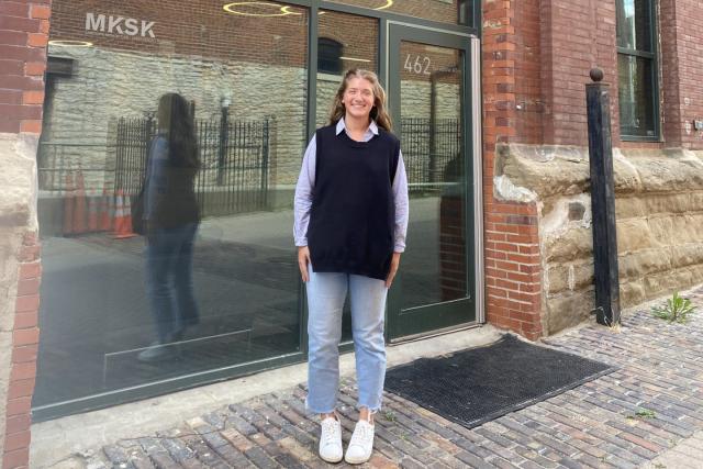 Clare Matthews stands in front of the door to MKSK