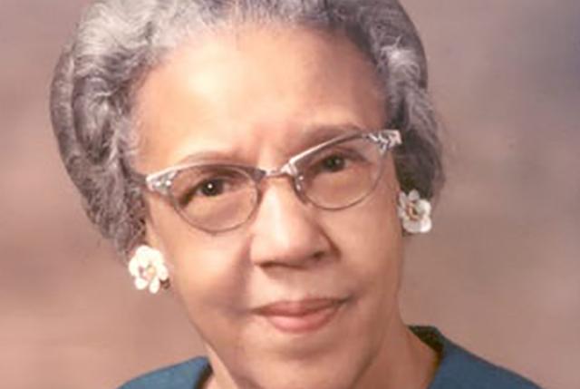 Ruth Ella Moore in cat's eyes glasses, grey hair and pearl earrings