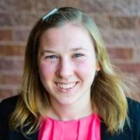 Hannah Sternig with blond hair, a bright pink blouse and black jacket