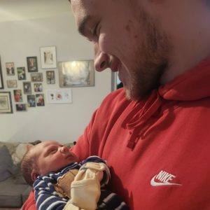 Logan Hudson holding his son, looking into his eyes and smiling